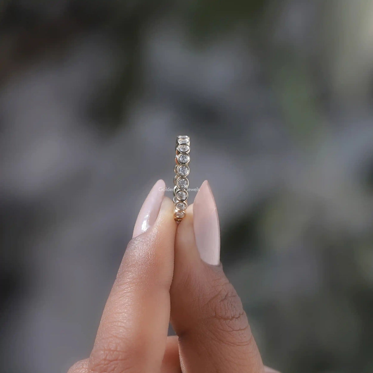 Side View of Round Cut Bezel Set Full Eternity Band In two fingers