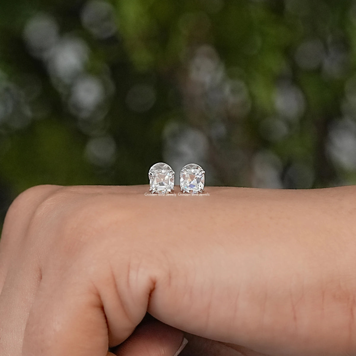 Pair of cushion-cut moissanite stud earrings with faceted stones and silver-tone settings
