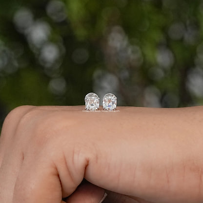 Pair of cushion-cut moissanite stud earrings with faceted stones and silver-tone settings