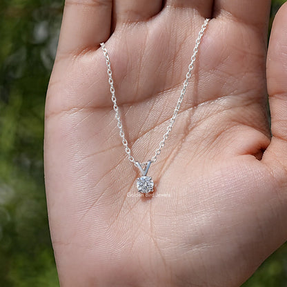 Silver round moissanite solitaire pendant on fine chain, shown on open palm