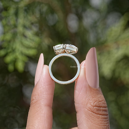 Open side view of a toi et moi ring with emerald-cut and heart-shaped moissanite stones.
