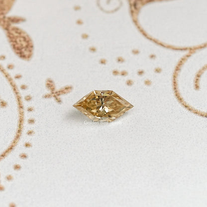 Marquise-cut golden moissanite gemstone with pointed ends and faceted sparkle